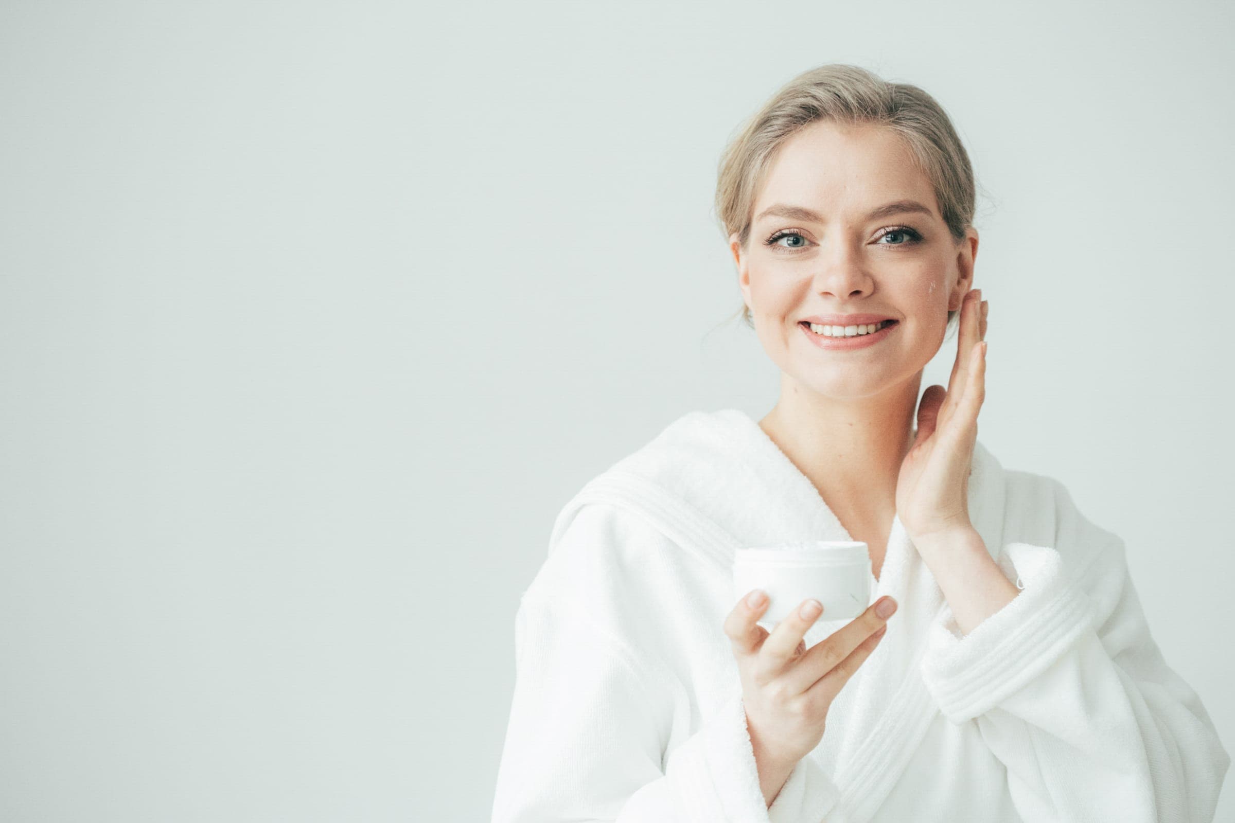 Freundliche Frau im Bademantel mit Pflegecreme – Kontakt zum Magnolia Kosmetikstudio