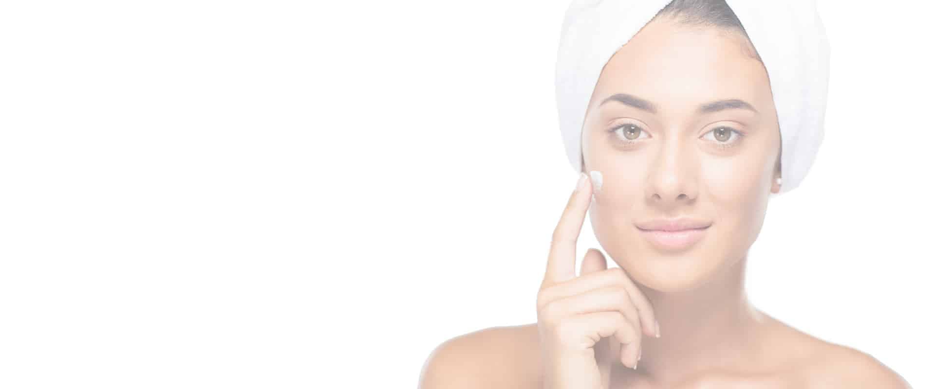 Frau mit Handtuch-Turban trägt Pflegecreme auf – Kosmetikstudio Magnolia Obertshausen